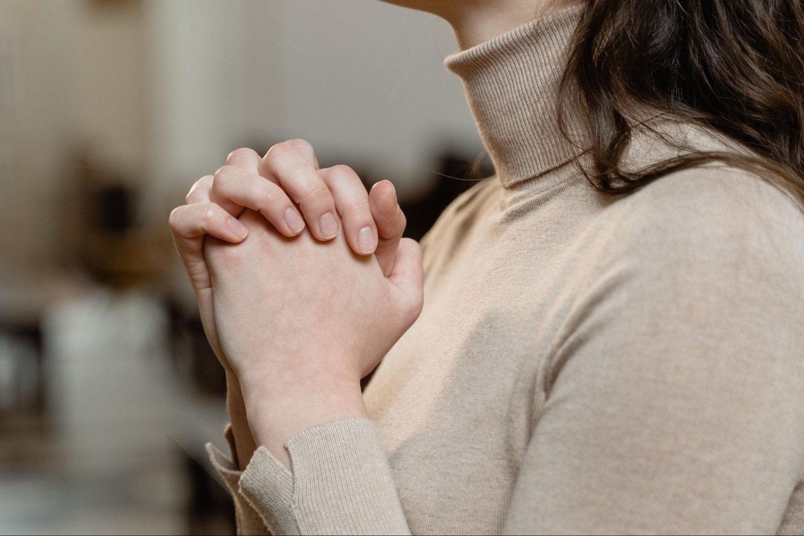 A woman with her hands clasped in prayer
